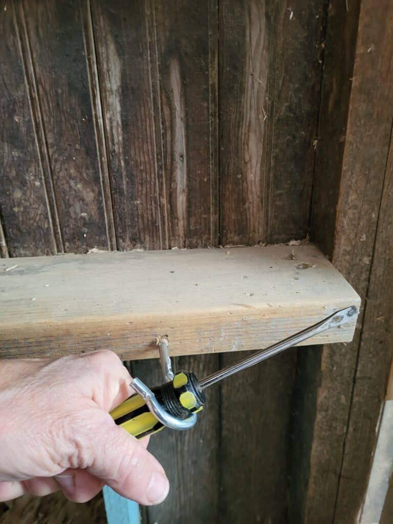 Install a screw hook to hold the nesting box curtain.